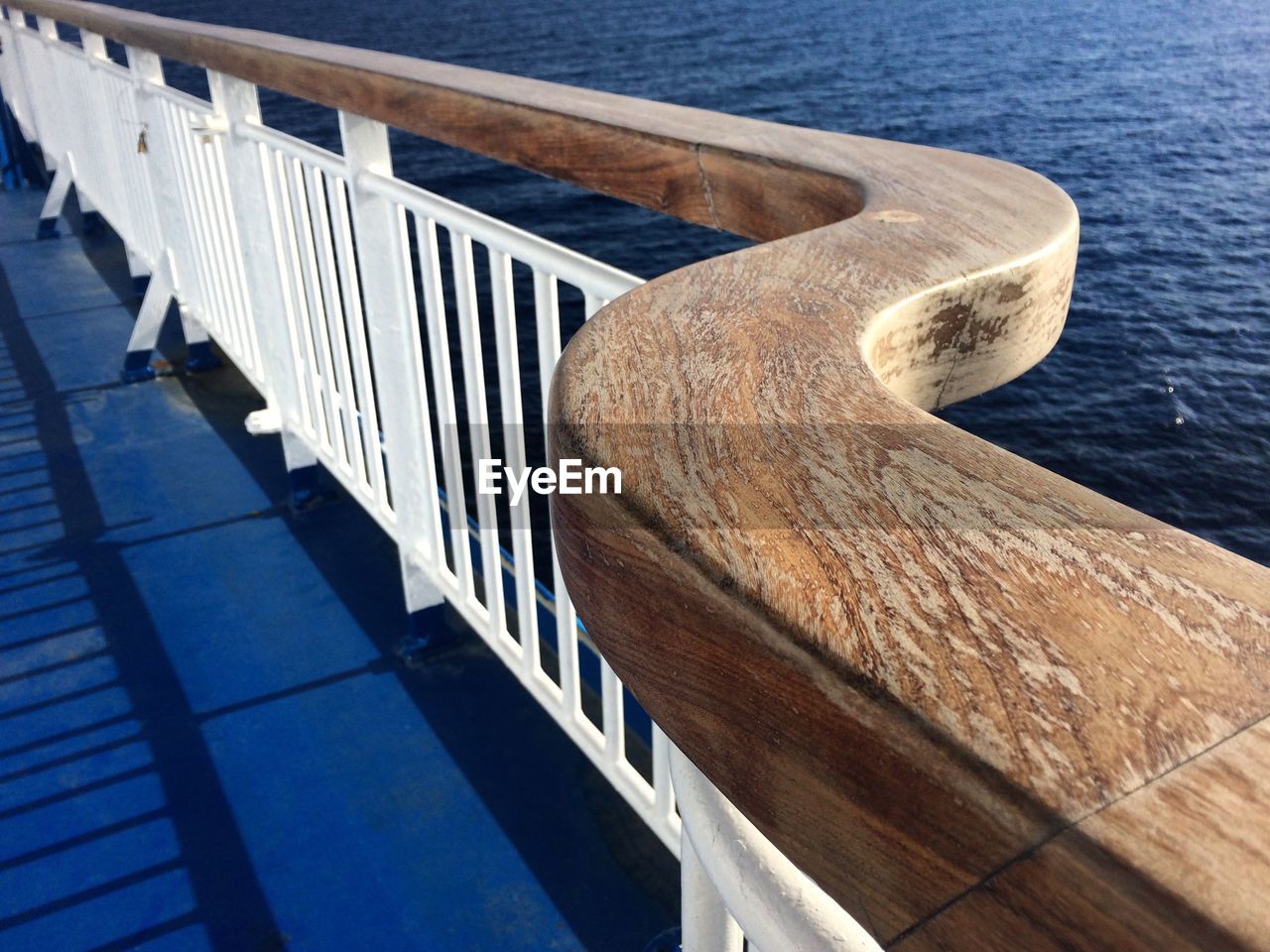 CLOSE-UP OF RAILING BY SEA