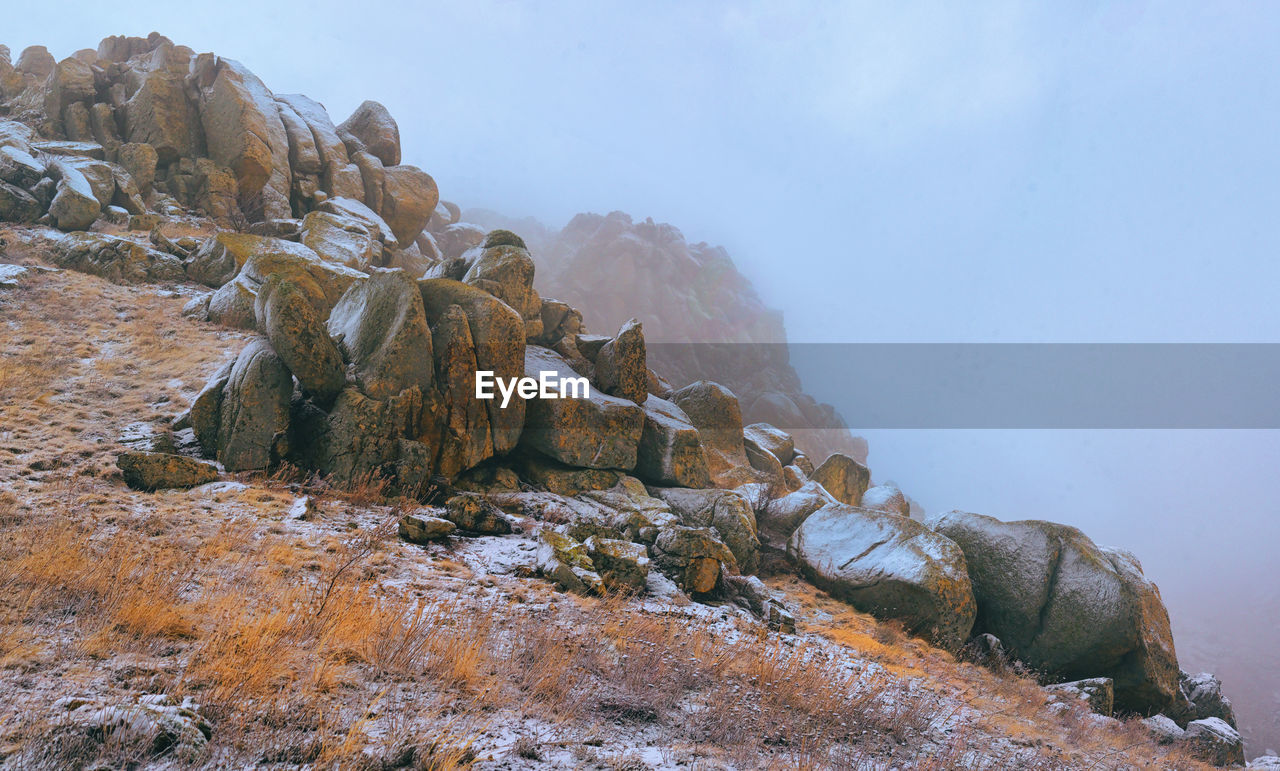 wilderness, rock, mountain, environment, landscape, nature, scenics - nature, sky, travel, land, beauty in nature, geology, travel destinations, mountain range, snow, ridge, no people, adventure, outdoors, terrain, summit, fog, winter, cliff, cold temperature, water, activity, tourism, cloud, non-urban scene, tranquility, animal wildlife, rock formation, day, social issues, panoramic