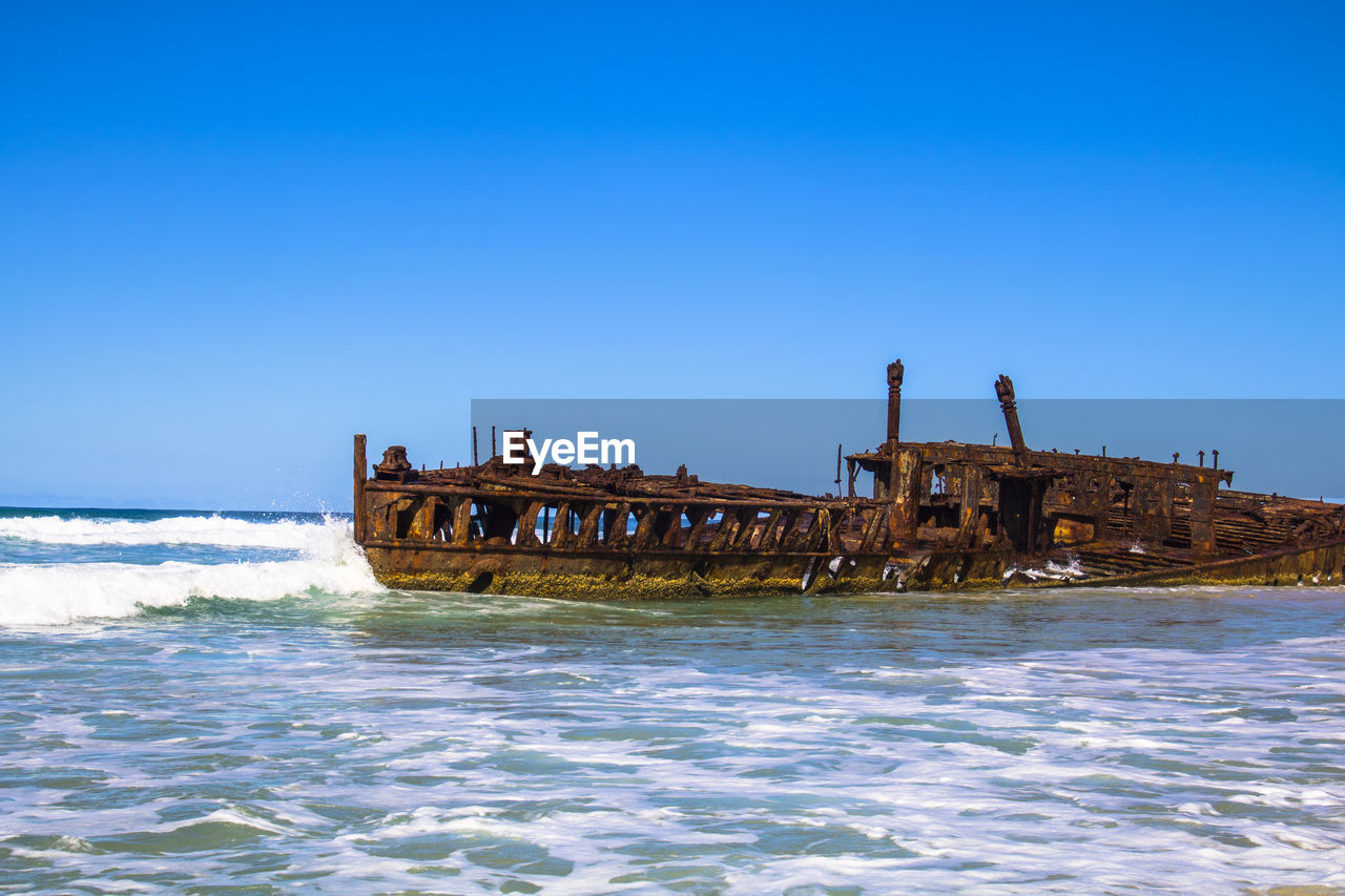 VIEW OF SHIP IN SEA AGAINST CLEAR BLUE SKY