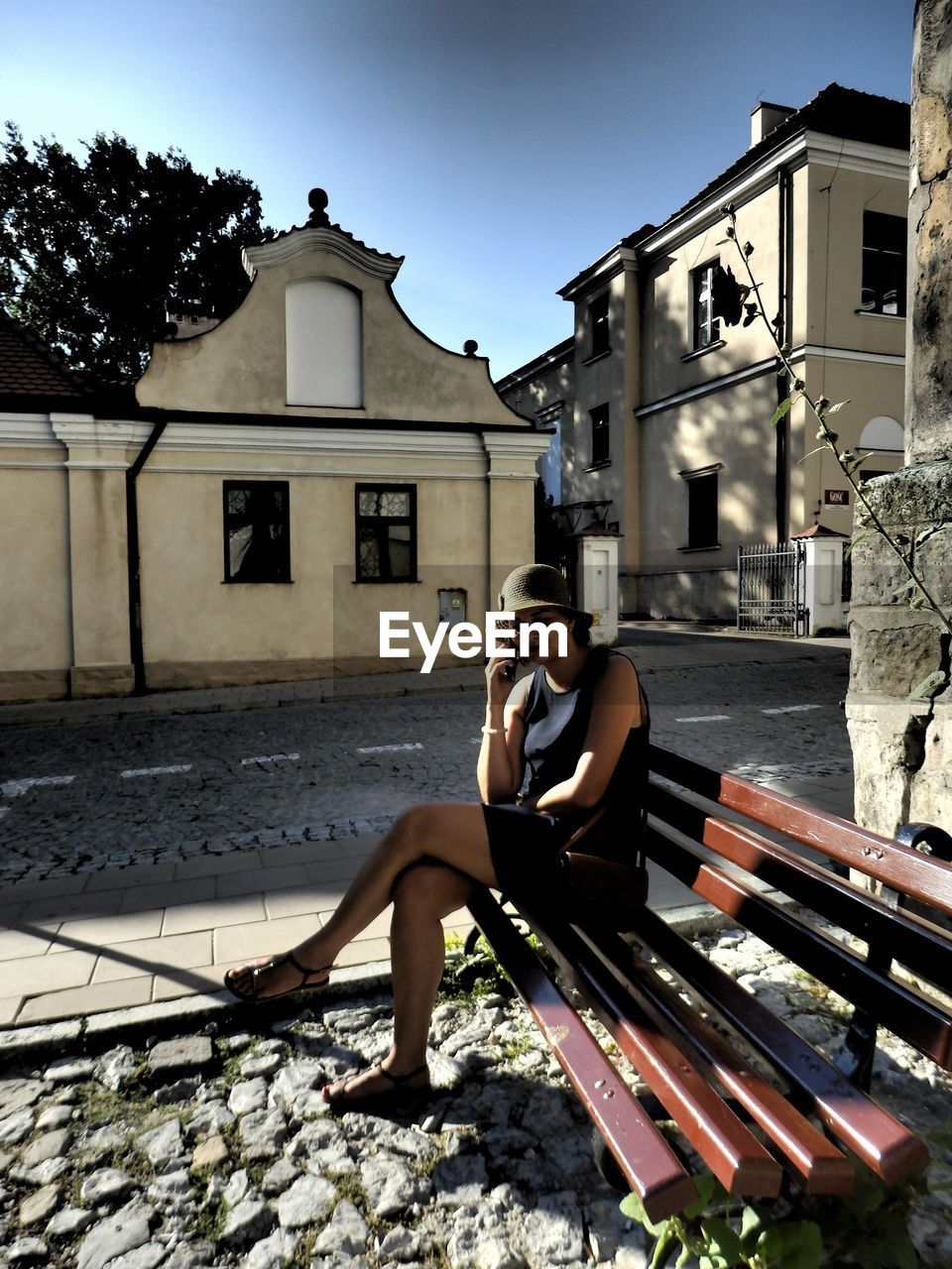 FULL LENGTH OF SHIRTLESS YOUNG WOMAN RELAXING OUTDOORS