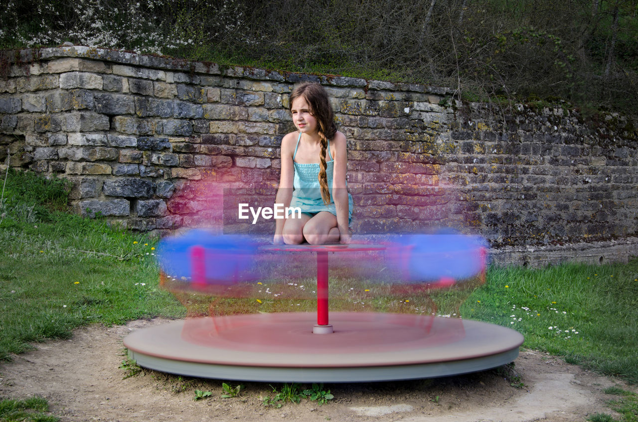 Girl playing on merry-go-round at playground