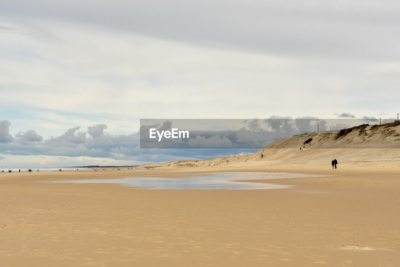 scenic view of beach against cloudy sky