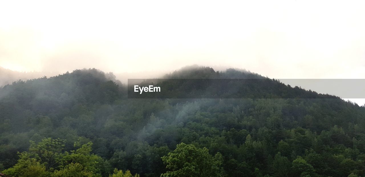 SCENIC VIEW OF FOG OVER MOUNTAINS AGAINST SKY