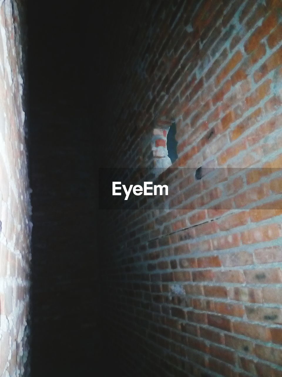 CLOSE-UP OF BRICK WALL WITH SHADOW OF WALLS ON FLOOR