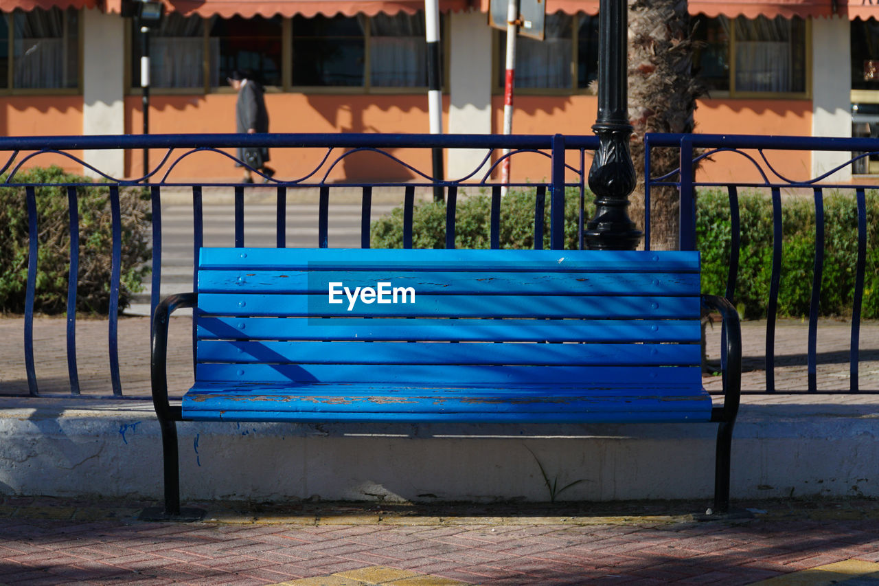 Empty blue bench at park