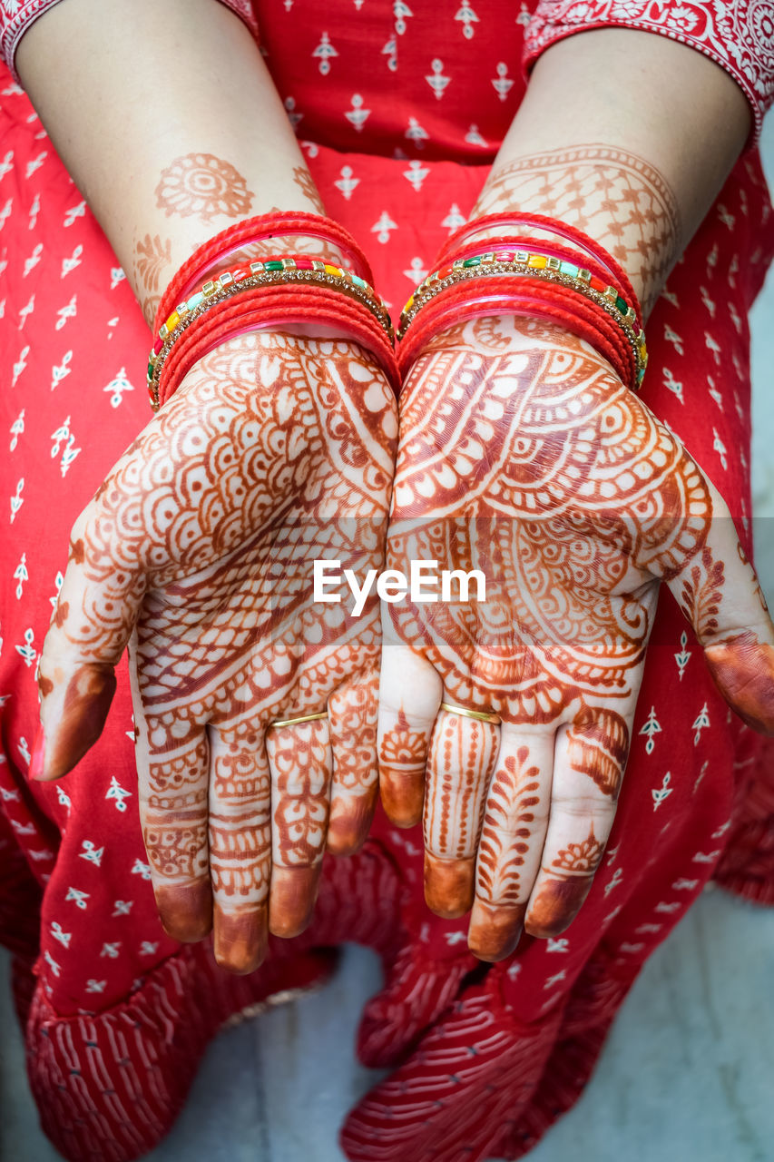 Beautiful woman dressed up as indian tradition with henna mehndi design on her both hands 