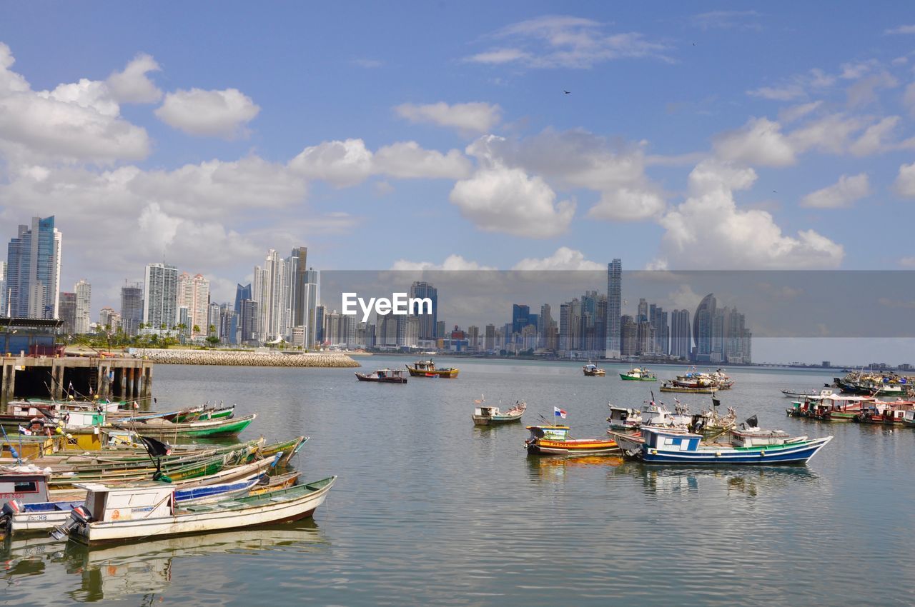 Boats in river with cityscape in background