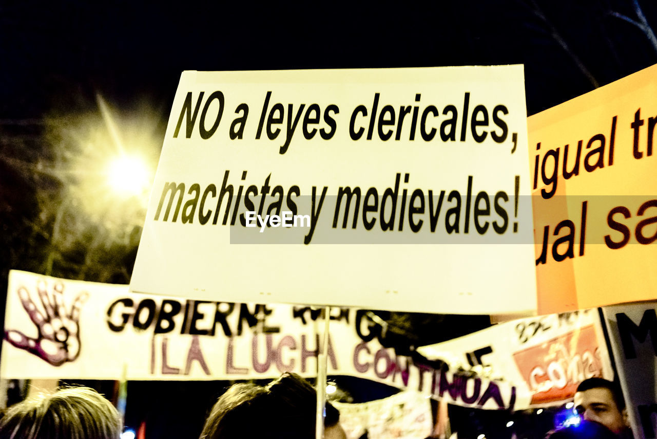 Cropped image of protestors with banners at night