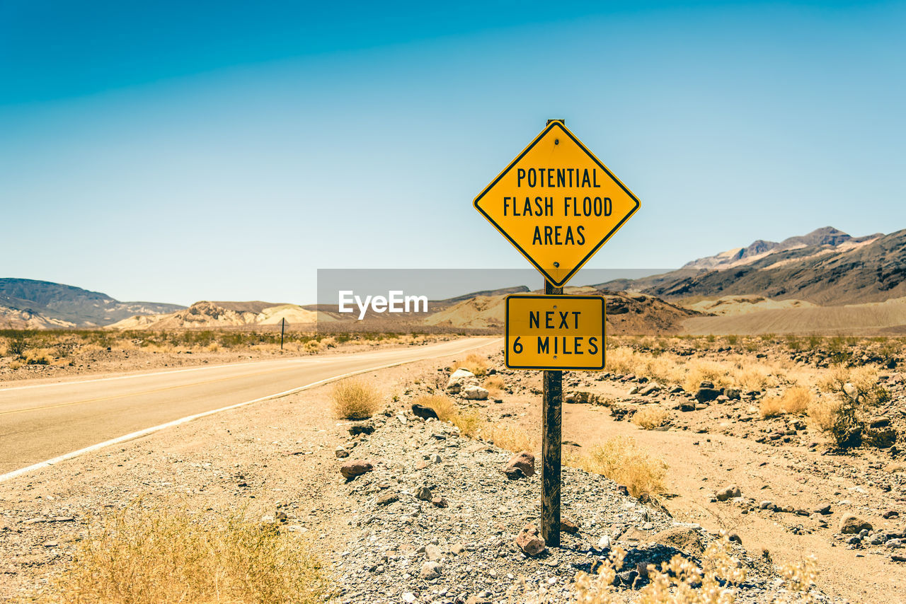 Information sign on road against clear sky