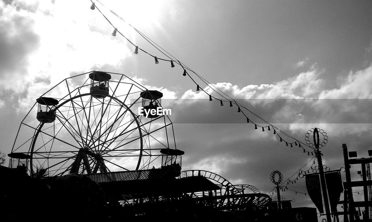 amusement park, sky, low angle view, arts culture and entertainment, cloud - sky, amusement park ride, outdoors, ferris wheel, silhouette, day, built structure, no people, nature, carousel