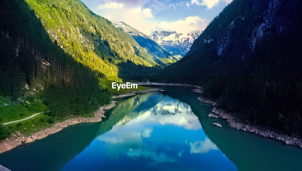 Scenic view of lake and mountains against blue sky