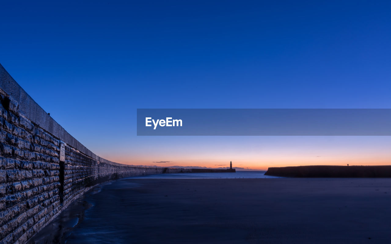 Bridge against clear blue sky during sunset