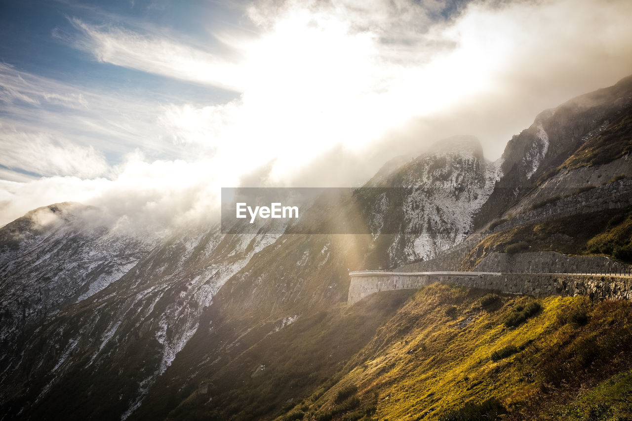 Scenic view of mountains against cloudy sky during winter