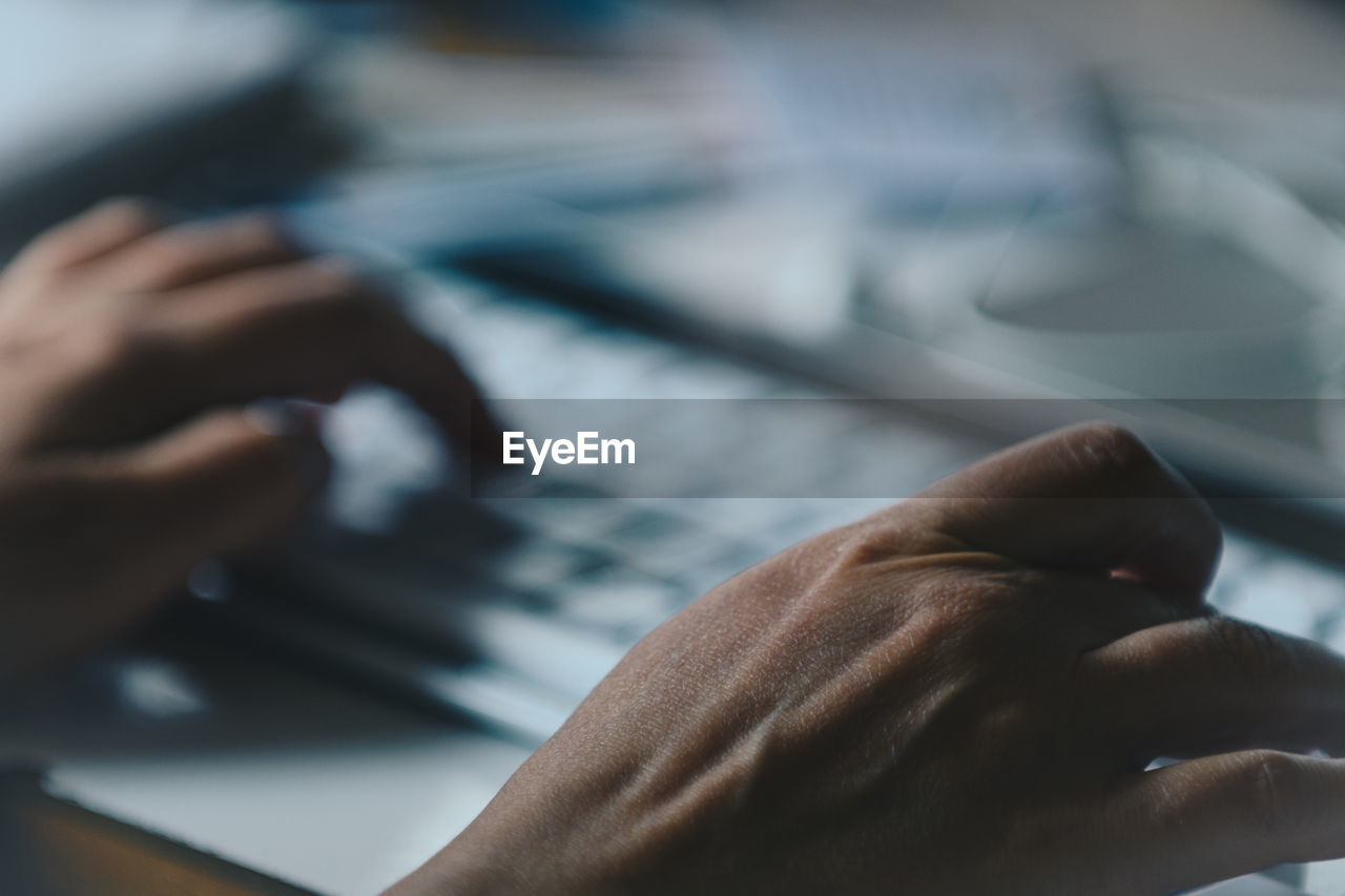 Close-up of hands using laptop