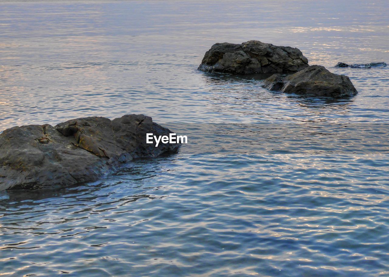 HIGH ANGLE VIEW OF ROCK FORMATIONS IN SEA