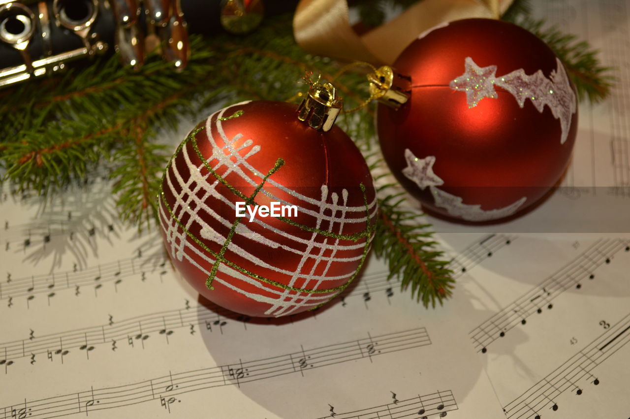 Close-up of christmas ornaments on musical notes