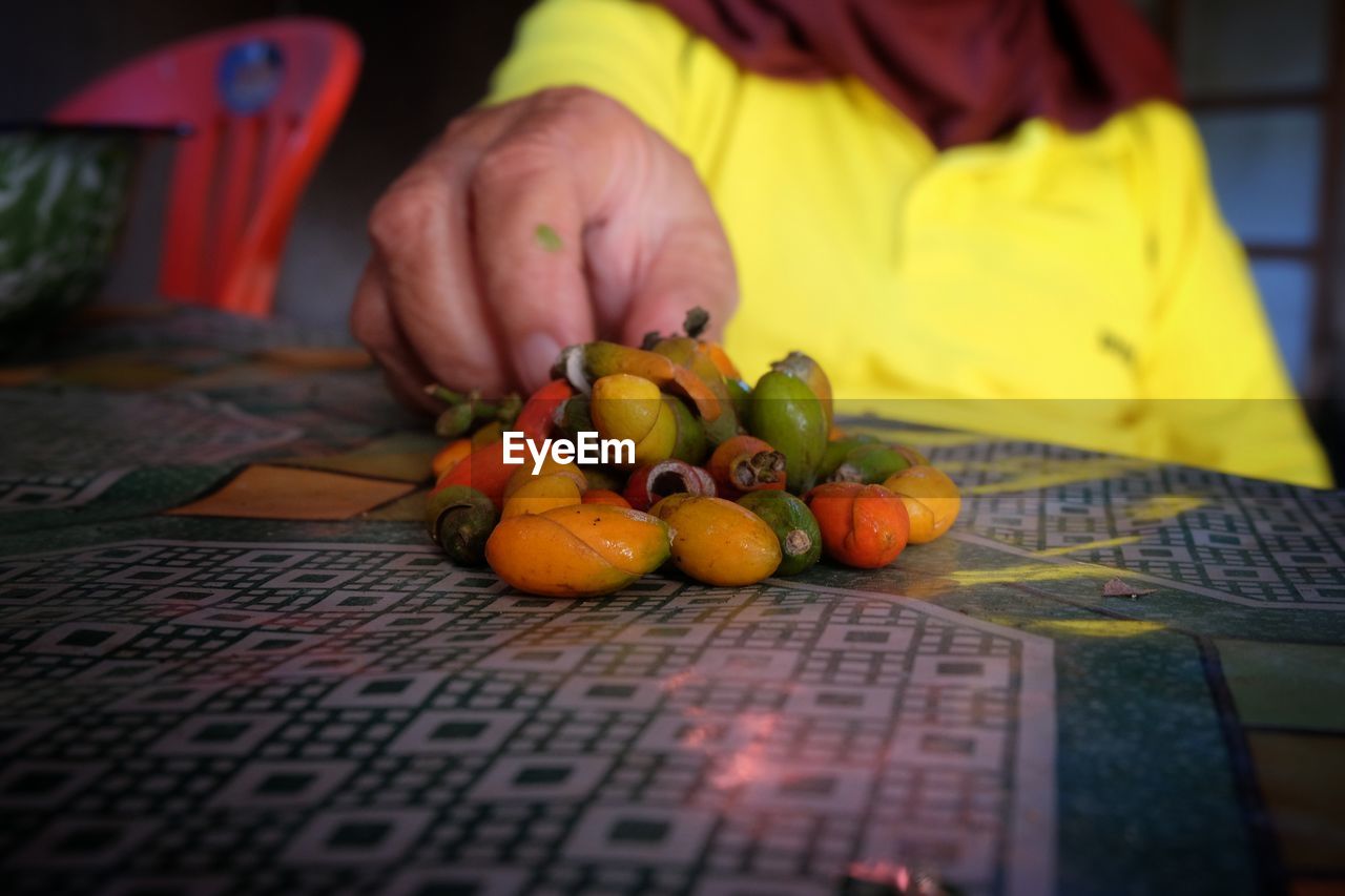 CLOSE-UP OF PERSON HOLDING FRUITS