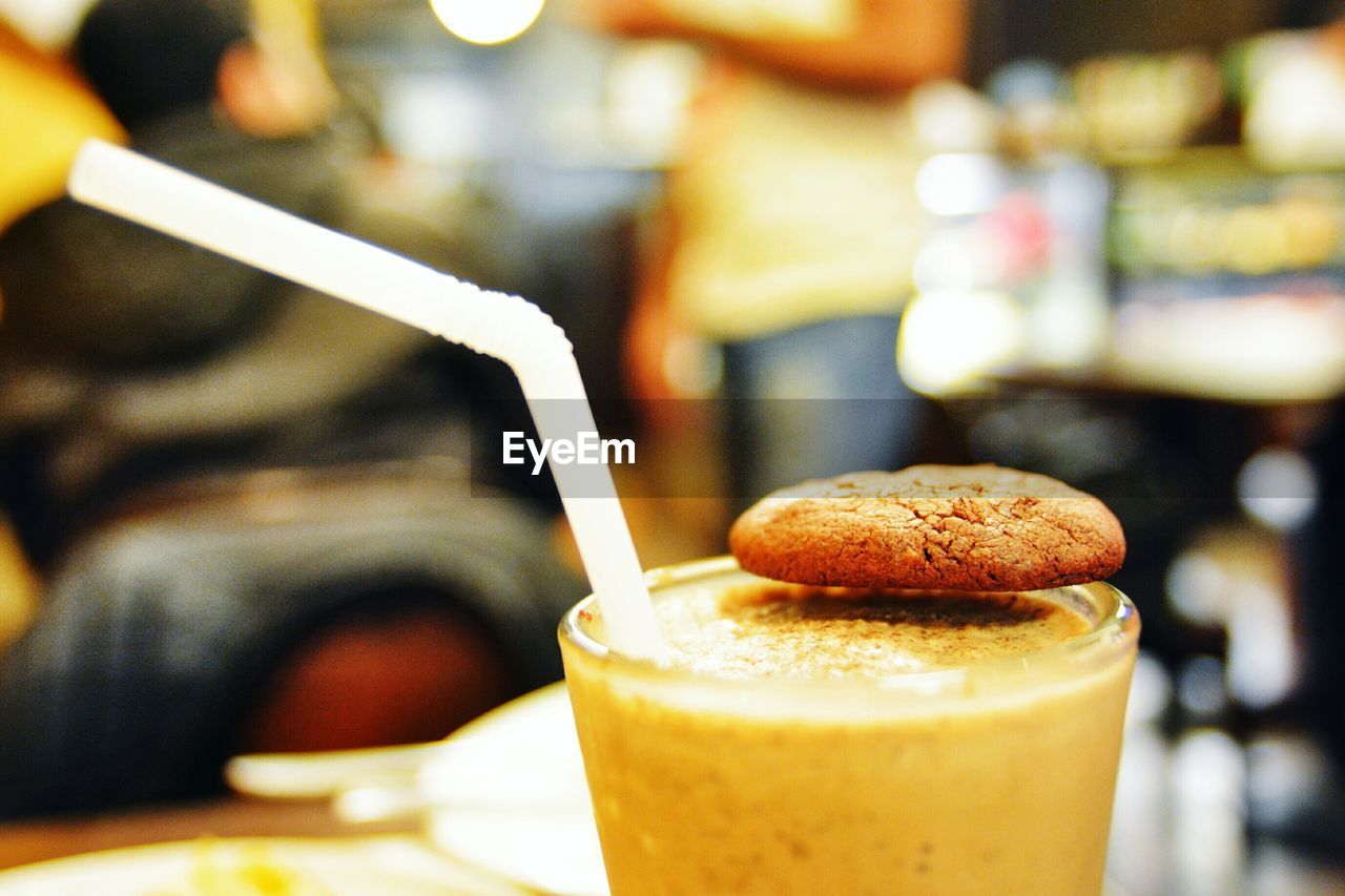 Close-up of chocolate milkshake with cookie garnished with cookie on table