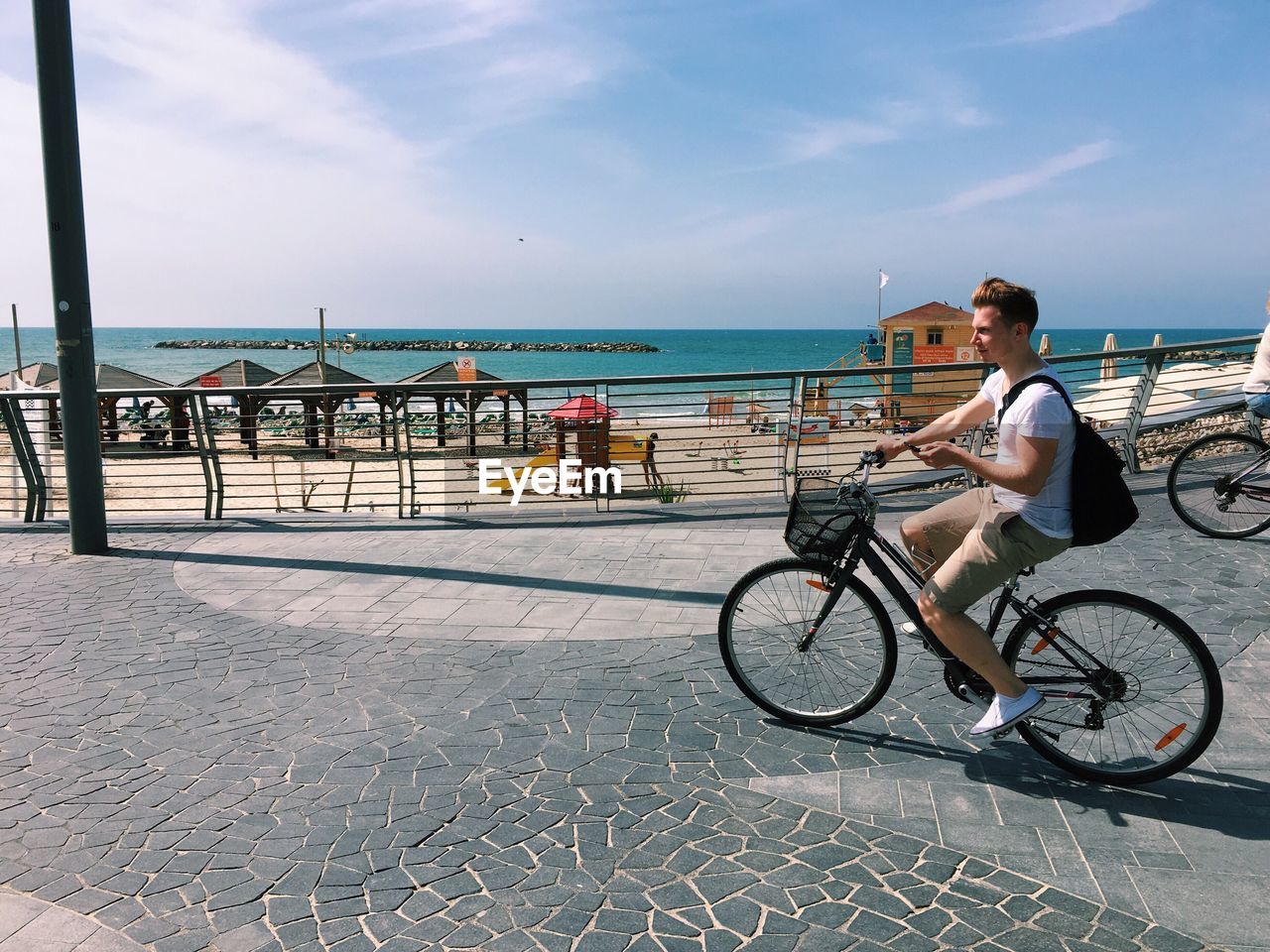 Young man riding bicycle on shore