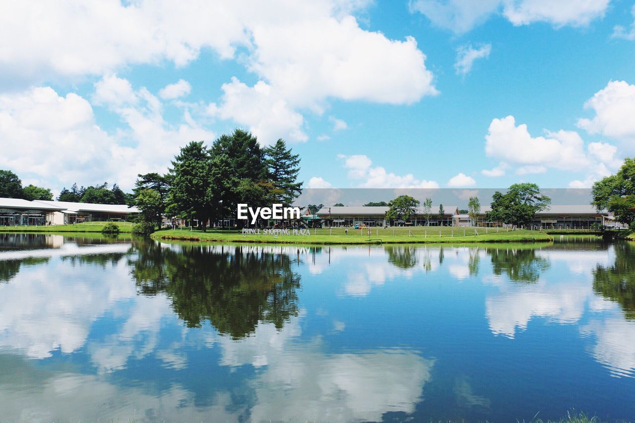 VIEW OF CALM LAKE AGAINST BLUE SKY