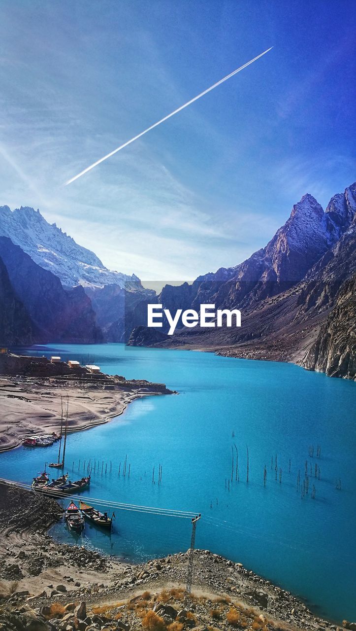 Scenic view of lake and mountains against blue sky