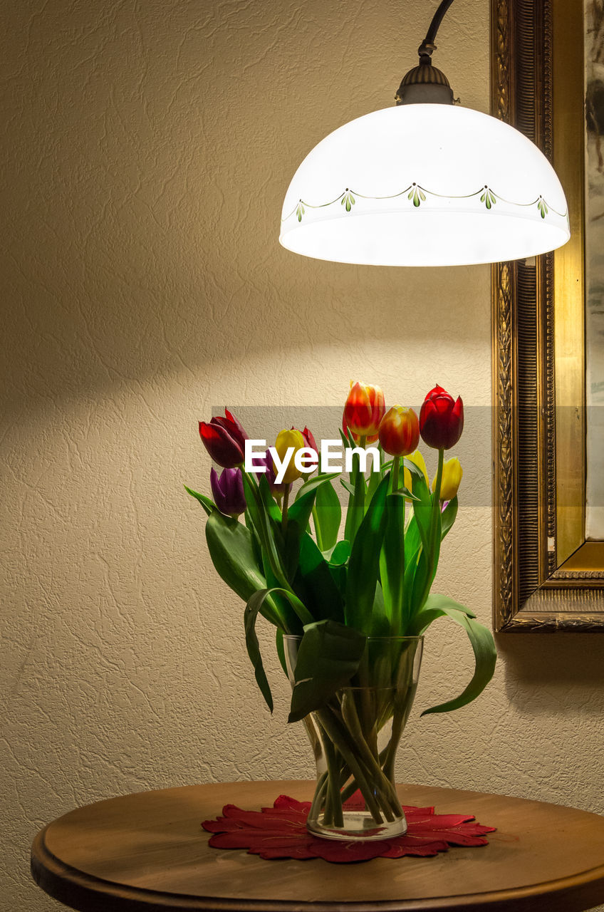 Tulips in vase on table at home