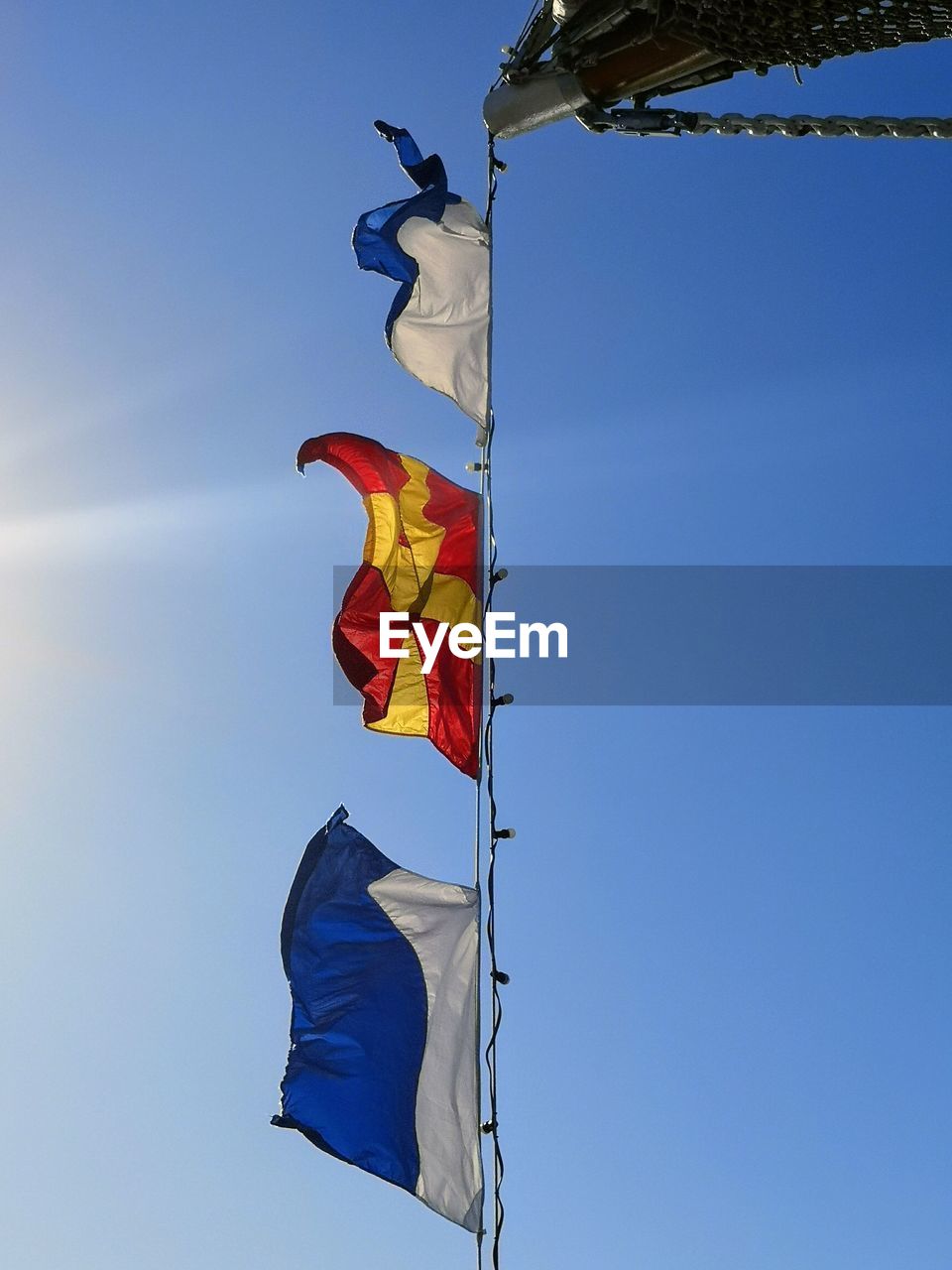 Low angle view of flag hanging against blue sky