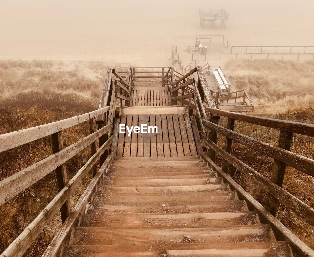 Staircase leading towards bridge against sky