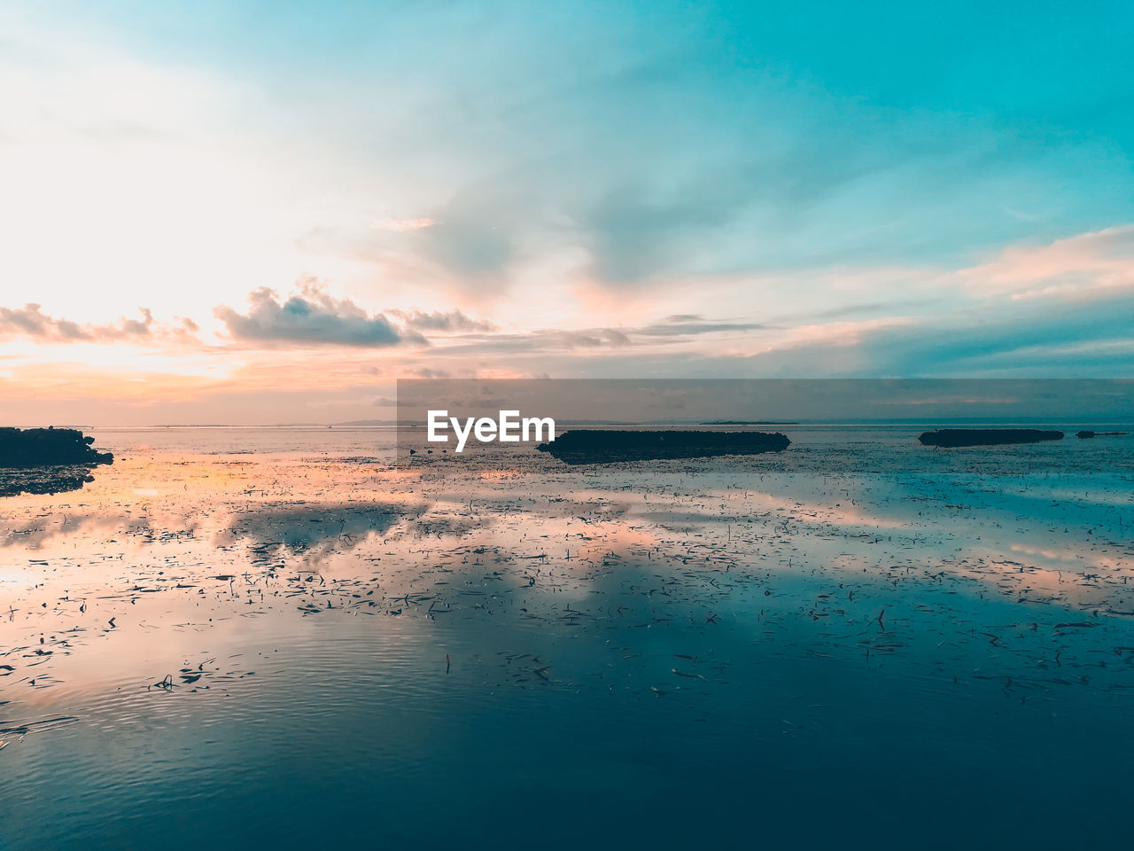 SCENIC VIEW OF BEACH AGAINST SKY AT SUNSET