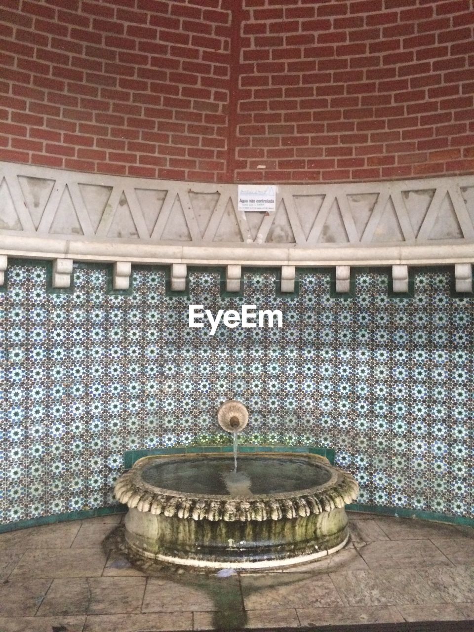 Fountain against patterned wall