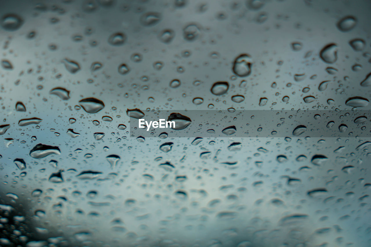 FULL FRAME SHOT OF WET GLASS WINDOW DURING RAINY SEASON