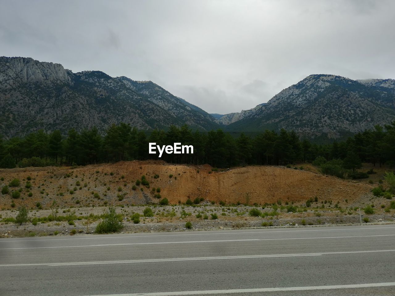 Scenic view of road by mountains against sky