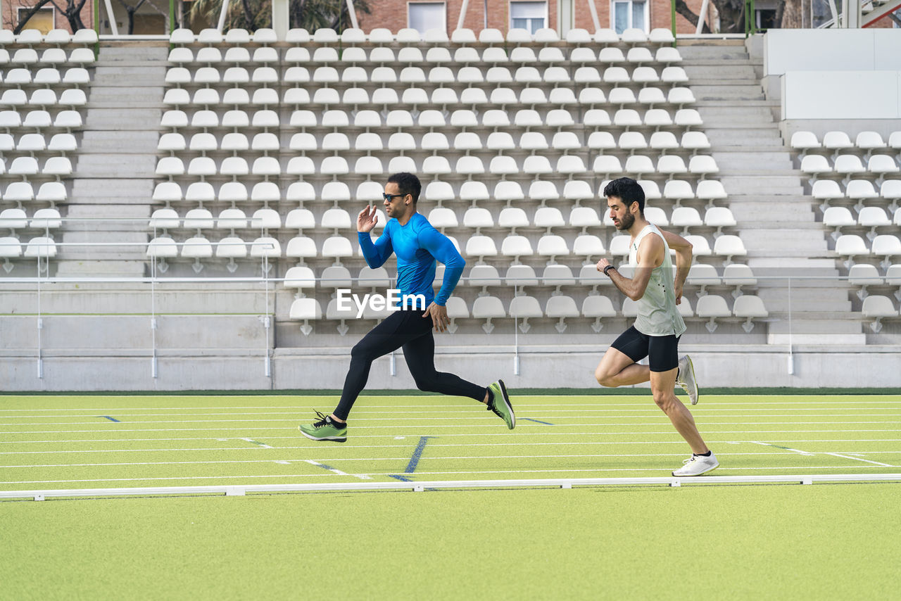 Male athletes running at sports field