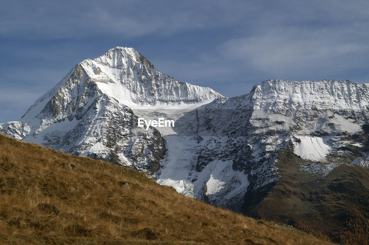 Scenic view of mountains against cloudy sky