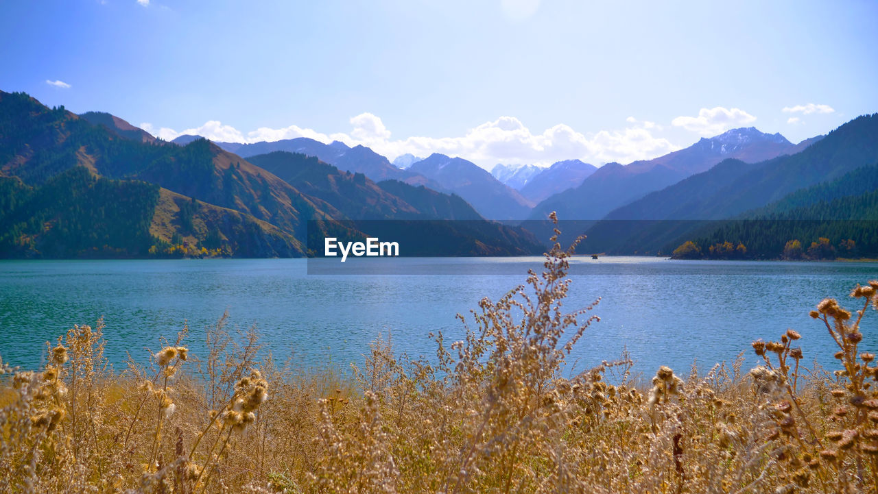 Scenic view of lake by mountains against sky