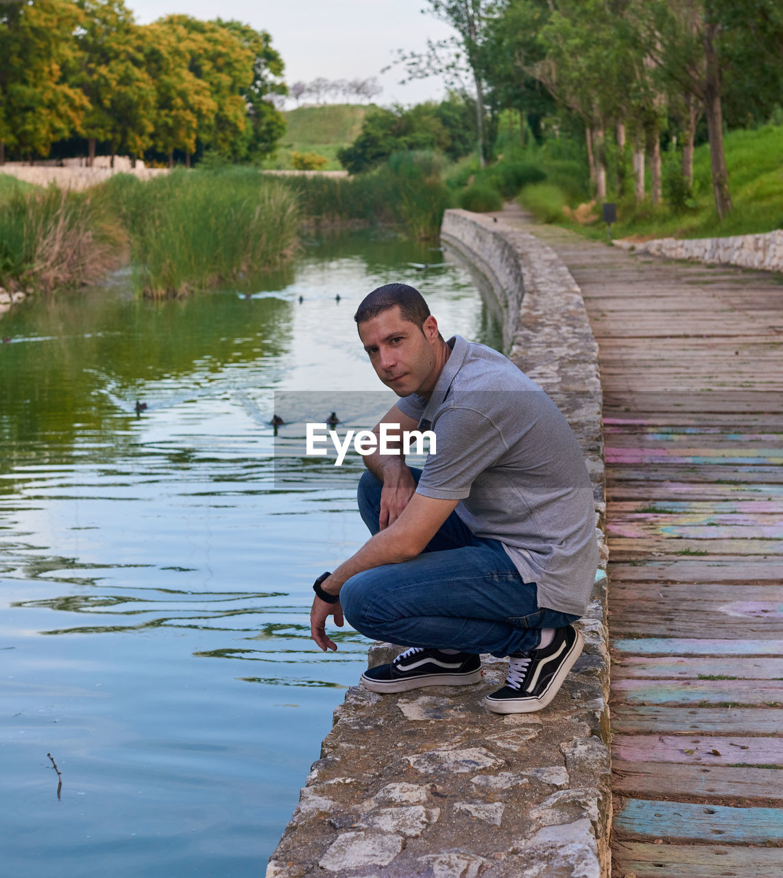 water, one person, men, adult, nature, full length, sitting, lake, plant, tree, casual clothing, leisure activity, day, lifestyles, side view, outdoors, fishing, young adult, crouching, occupation, looking, activity, environment, rural scene