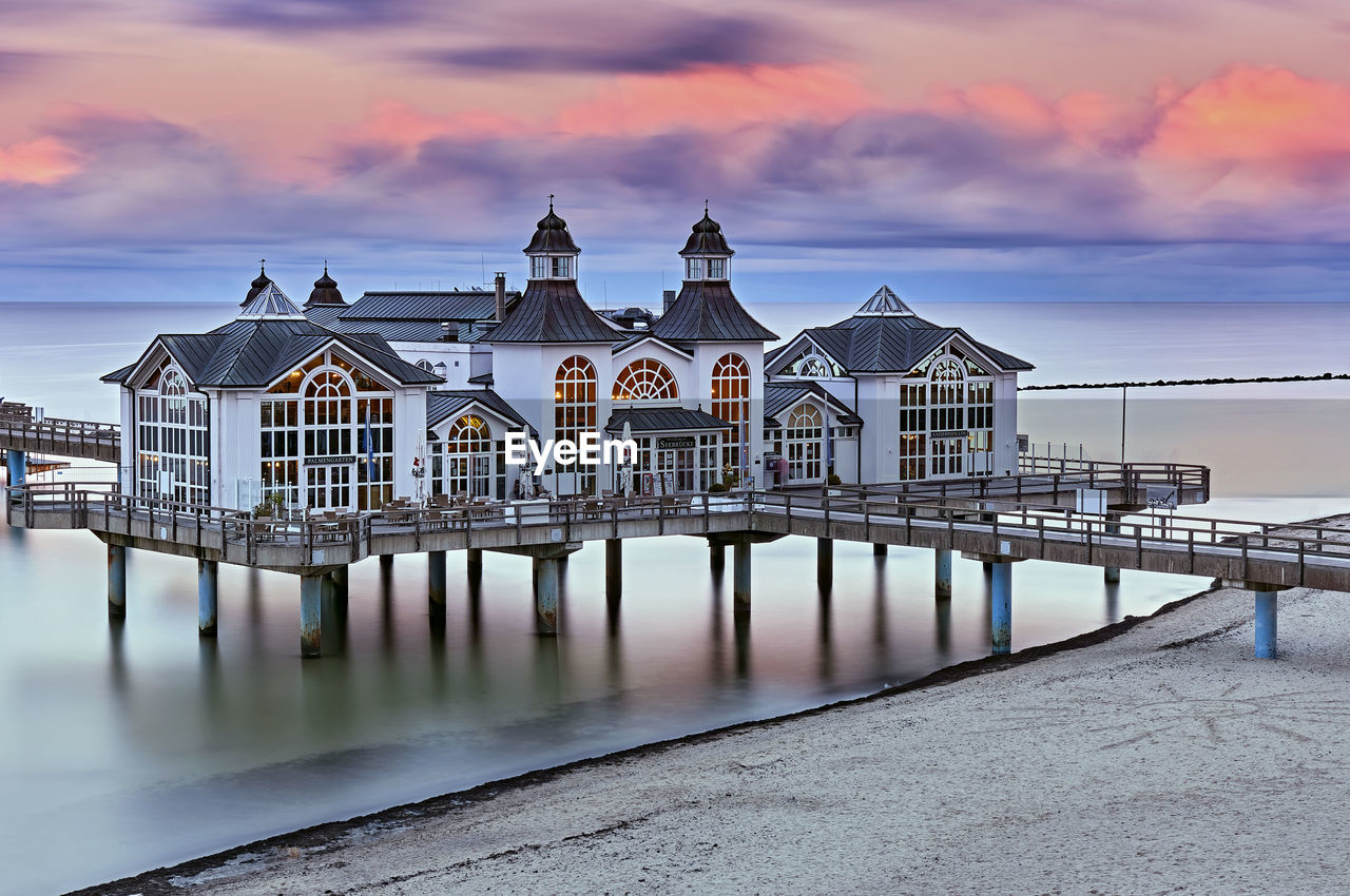 VIEW OF PIER OVER SEA AGAINST BUILDINGS