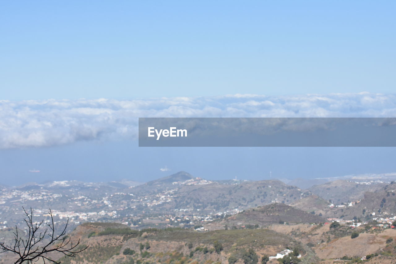 AERIAL VIEW OF LANDSCAPE AND MOUNTAINS AGAINST BLUE SKY