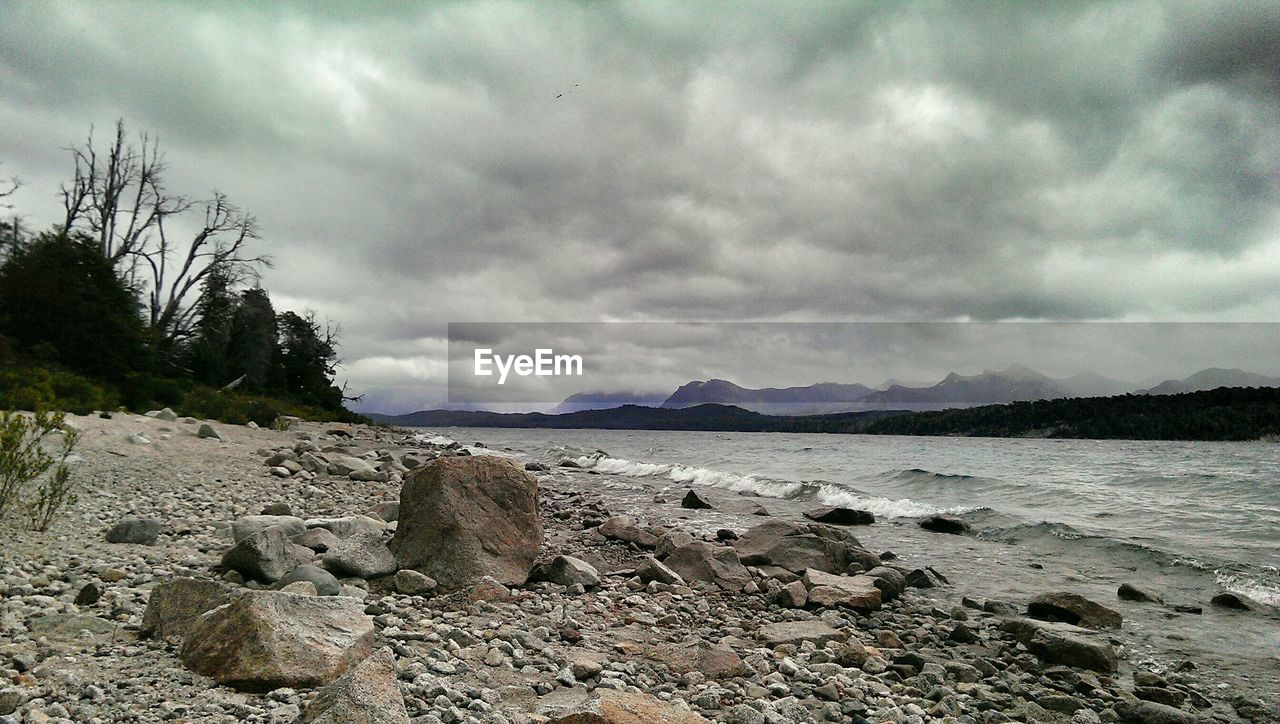 Scenic view of lake against cloudy sky