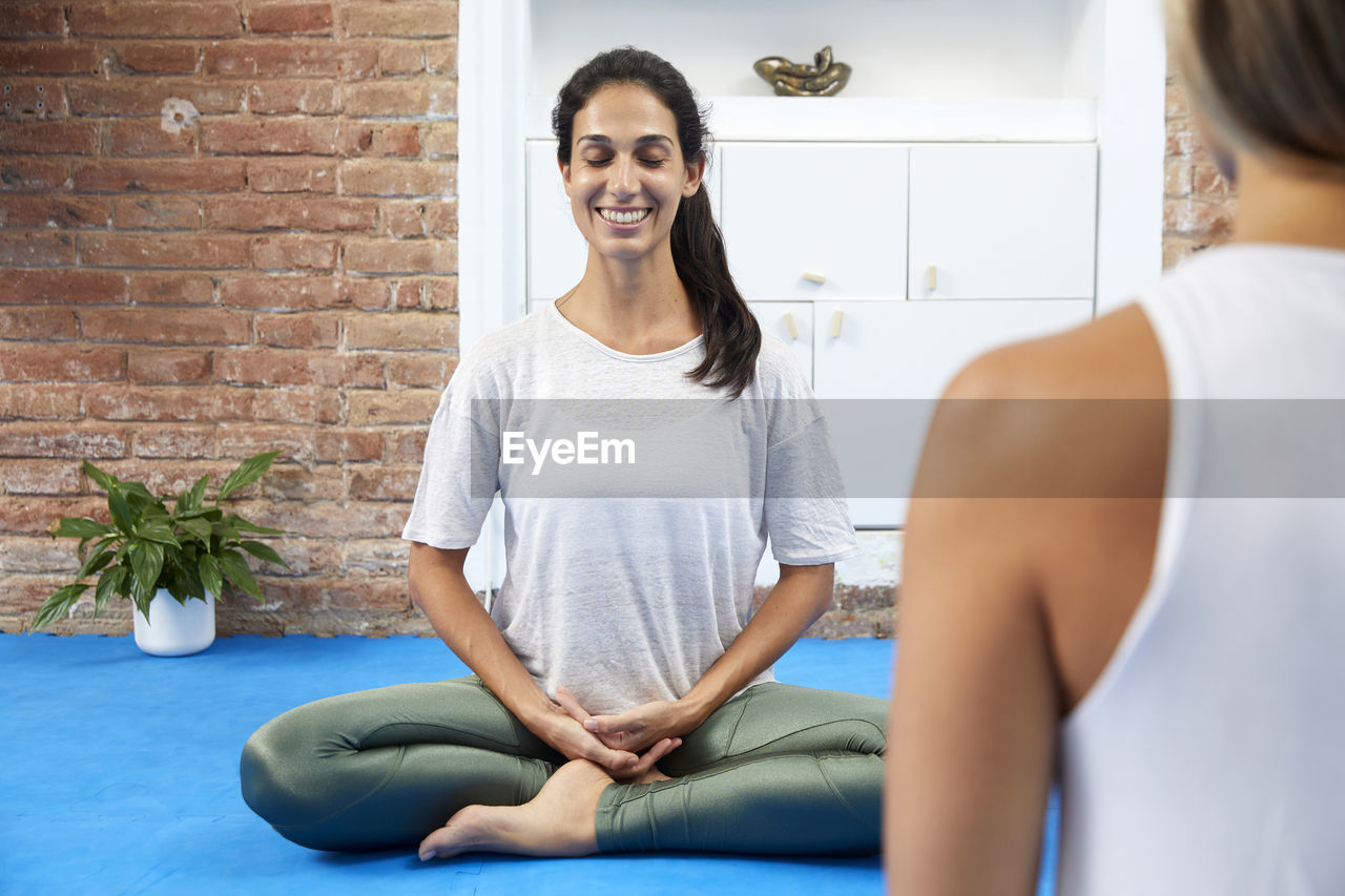 Young smiling woman meditating in a yoga class. smile to life
