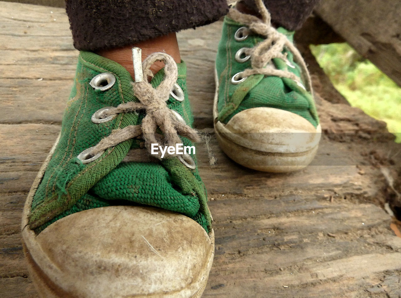 Low section of person wearing dirty shoes
