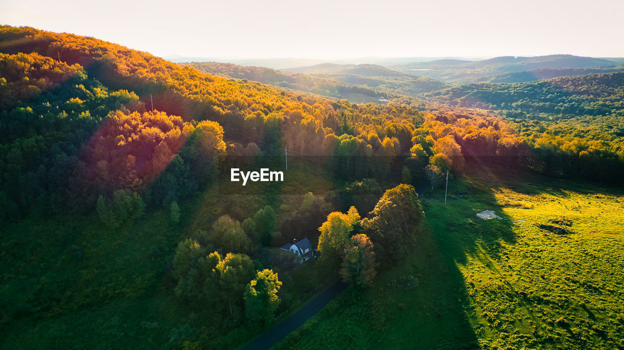 Arial shot of a mountain showing the first signs of fall foliage somewhere in the catskills region