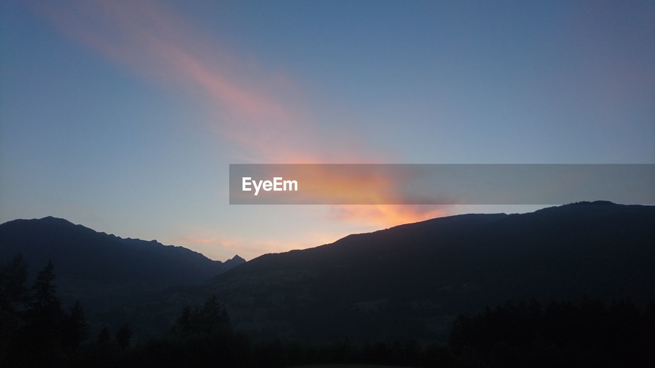 Scenic view of silhouette mountains against sky at sunset