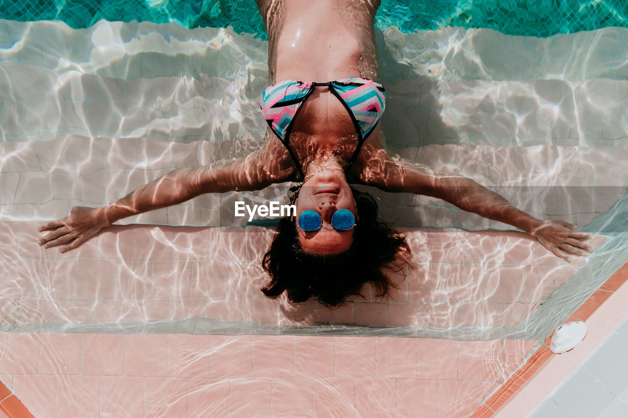 Directly above shot of woman relaxing in swimming pool