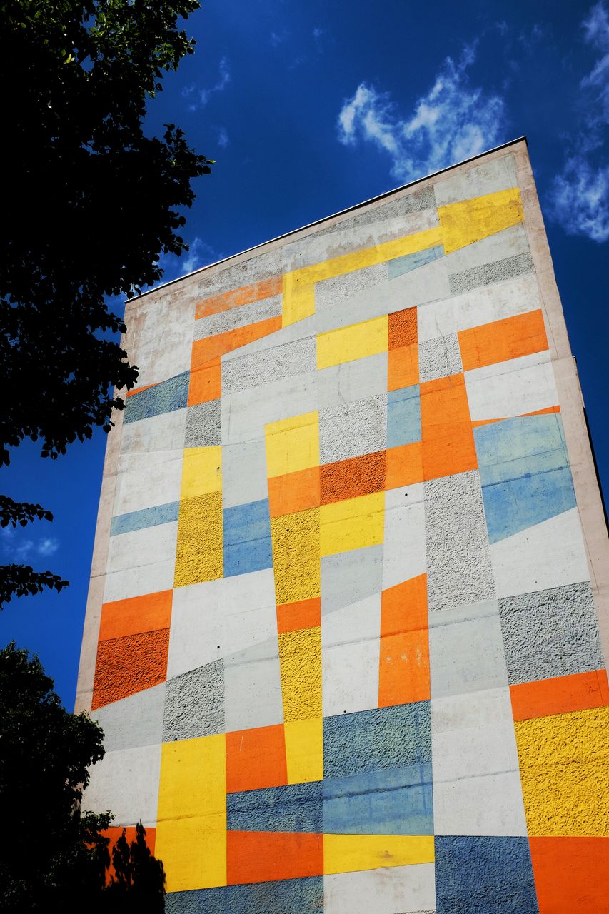 Low angle view of multi colored building against sky