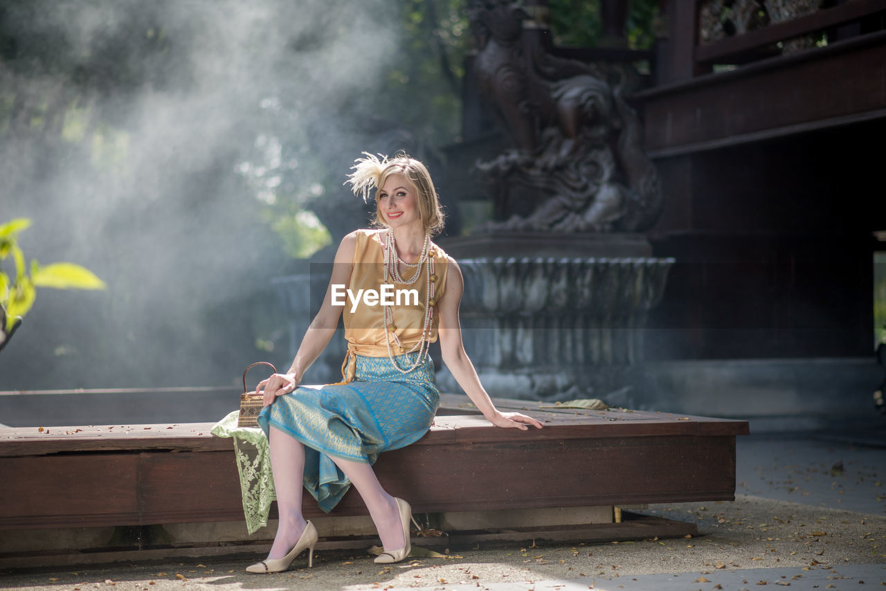 Full length of woman sitting outdoors