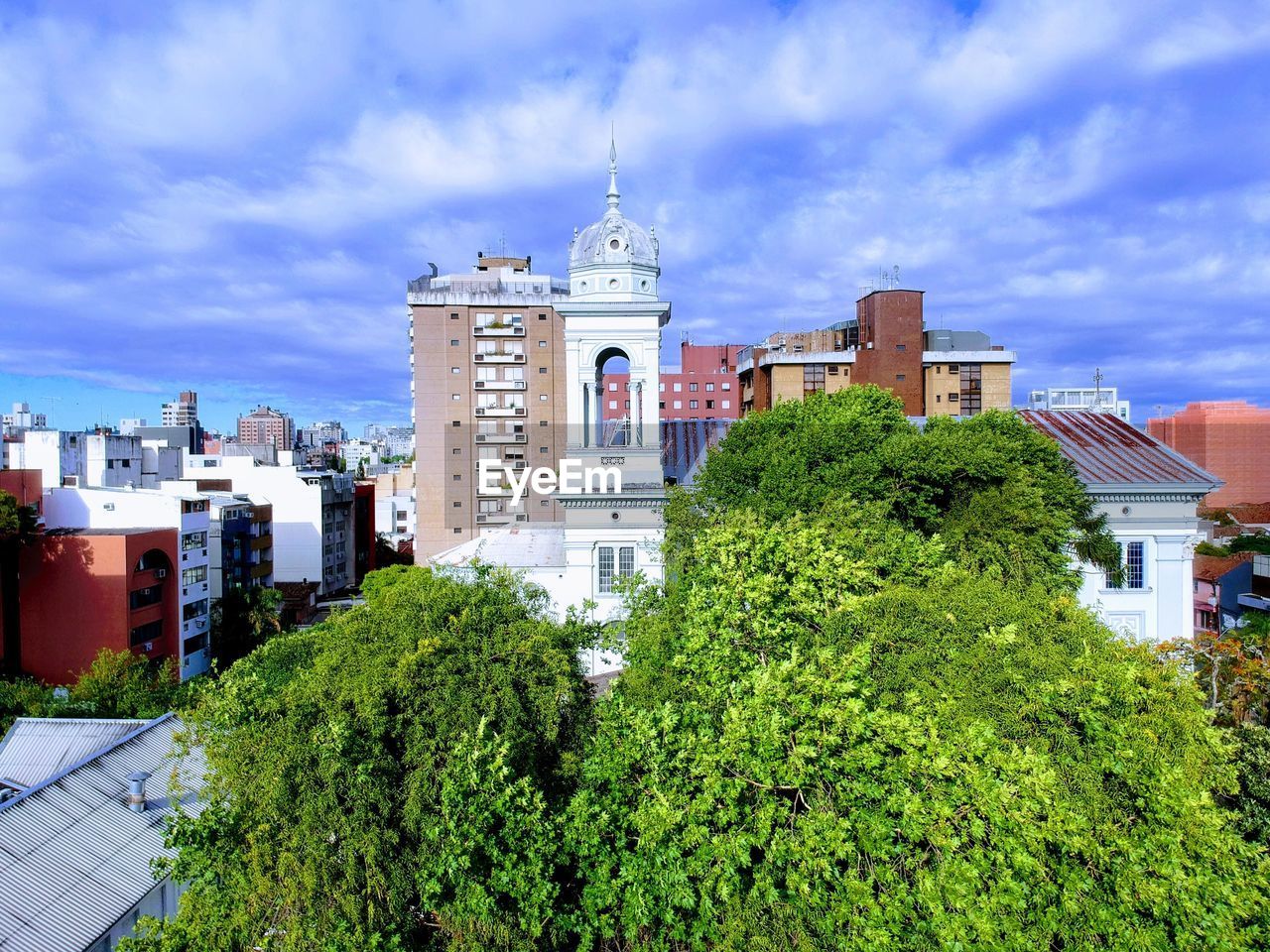 Panoramic view of trees and buildings against sky