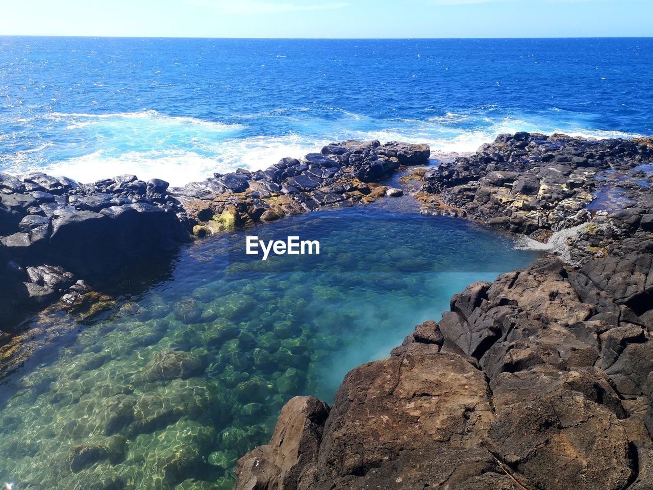 Scenic view of sea against rocks with turquoise water