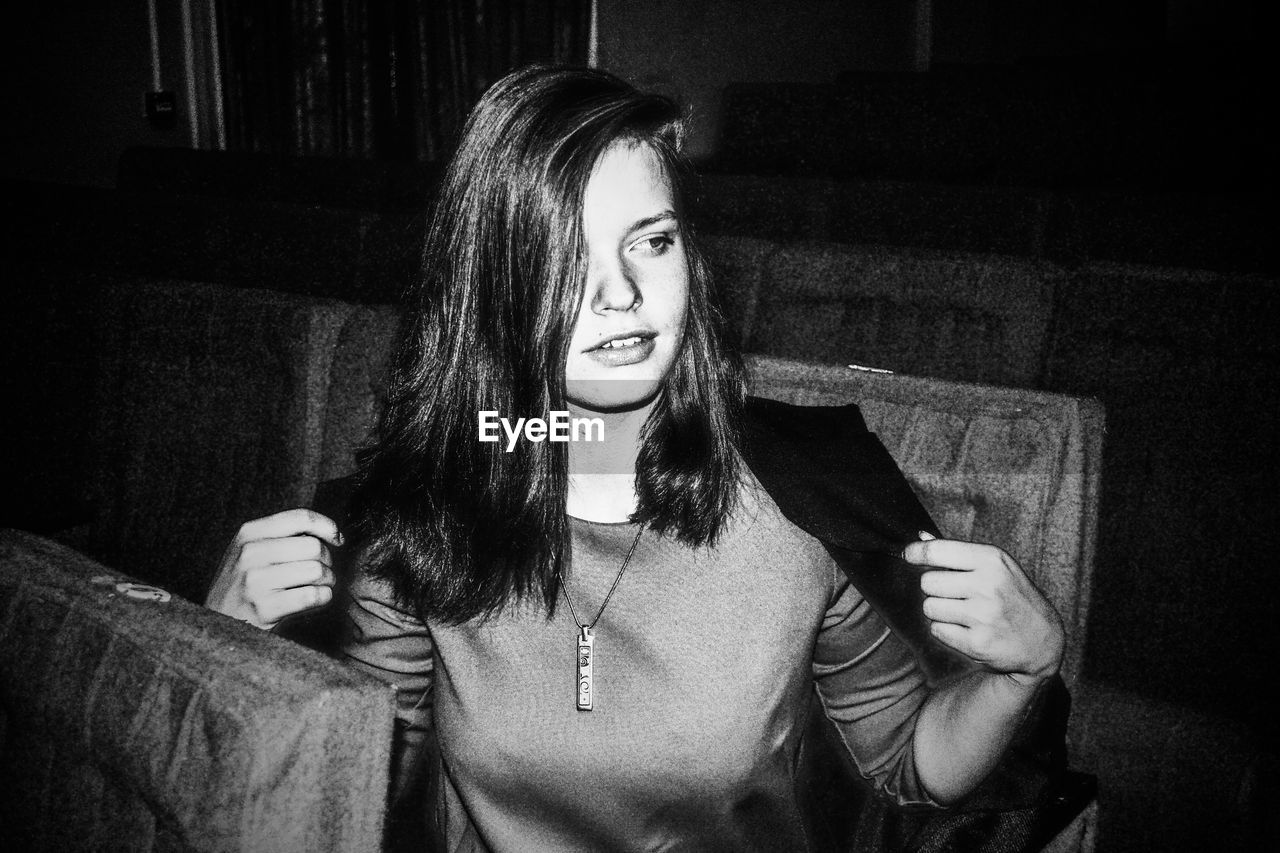 Woman looking away while sitting in dark