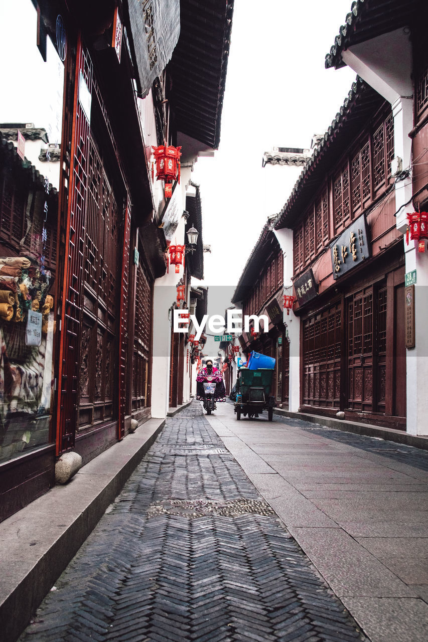 Street amidst buildings against sky in city